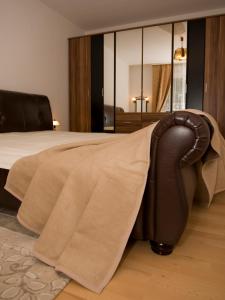 a bedroom with a bed with a blanket and a chair at Maria-Viktoria Apartment in Baden-Baden