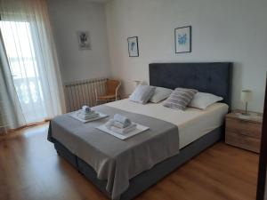 a bedroom with a large bed with towels on it at Apartments and Rooms Vinko in Barbat na Rabu