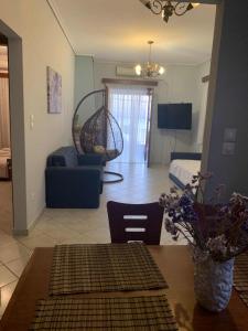a living room with a table and a room with a couch at Naiada Apartments Milina in Milína