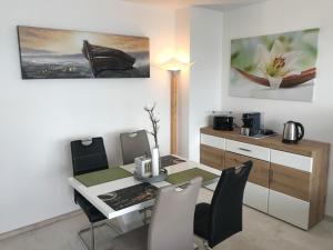 a dining room with a table with chairs and a desk at Penthouse - Sunset Dream in Uhldingen-Mühlhofen