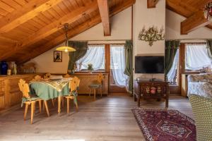- un salon avec une table et une télévision dans l'établissement Mansarda Belvedere - panoramica e wellness, à San Vito di Cadore