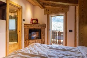 - une chambre avec un lit, une cheminée et une fenêtre dans l'établissement Lino Deluxe Suite, à Borca di Cadore