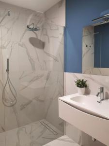 a white bathroom with a shower and a sink at ISTAI Cagliari City Center Rooms in Cagliari