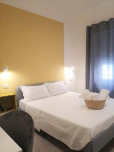 a bedroom with a white bed with a basket on it at ISTAI Cagliari City Center Rooms in Cagliari