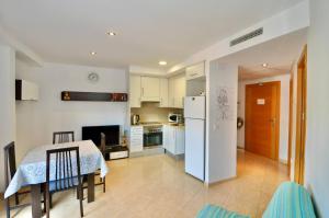 uma cozinha com uma mesa e um frigorífico branco em Apartment Nati em Lloret de Mar