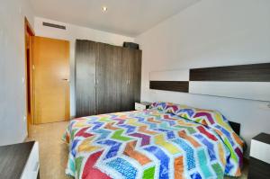 um quarto com um edredão colorido numa cama em Apartment Nati em Lloret de Mar