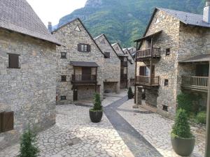 wiersz kamiennych budynków z doniczkami na dziedzińcu w obiekcie Apartamento de la Marmota w mieście Eriste