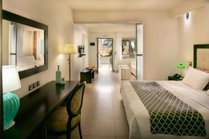 a bedroom with a bed and a desk and a room at Angela Suites Boutique Hotel in Sisi