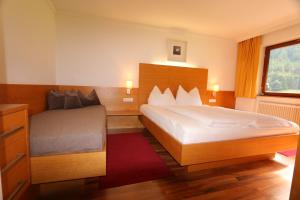 a hotel room with two beds and a window at Apart-Garni Alpevita in Mayrhofen