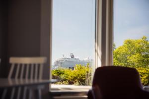 a cruise ship is seen through a window at Ravinstigen - Visby Lägenhetshotell in Visby