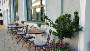 eine Reihe von Tischen und Stühlen auf einer Terrasse mit Blumen in der Unterkunft Hotel Feichtinger Graz in Graz