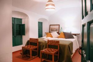 um quarto com uma cama e 2 cadeiras em Casa Rural Finca Buytrón em Montilla