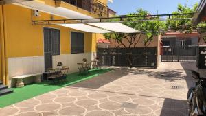 un patio avec une table et des chaises et un bâtiment dans l'établissement Villa Manto Bed and Breakfast - Torre Annunziata Pompei, à Torre Annunziata
