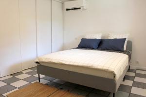Bett in einem Schlafzimmer mit einem karierten Boden in der Unterkunft VILLA ARVOR CANNES Appartement indépendant en bas de maison in Cannes
