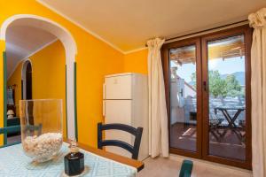 a kitchen with a table and a white refrigerator at Mansarda Marina in Villa San Pietro +17 photos
