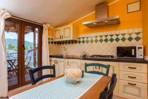 a kitchen with a table and chairs and a kitchen with a balcony at Mansarda Marina in Villa San Pietro
