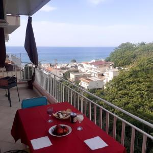 une table rouge avec une assiette de nourriture sur un balcon dans l'établissement L'angolo di Paradiso, à Alcamo