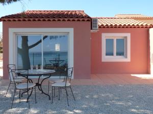 eine Terrasse mit einem Tisch und Stühlen vor einem Haus in der Unterkunft Residence de Tourisme la Provence in Istres