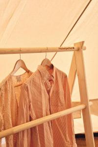a shirt hanging on a rack in a tent at The Quaives - Cottages & Glamping in Canterbury