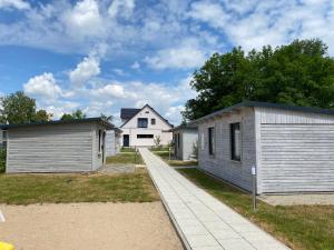 a house with two garages next to a sidewalk at La Maison Pritzwalk - Bett & Bike in Pritzwalk