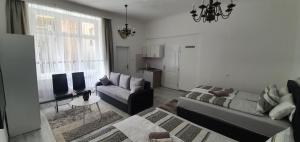 Una sala de estar con un sofá, una mesa y una silla. en Ferhadija A&E Apartment Sarajevo, en Sarajevo