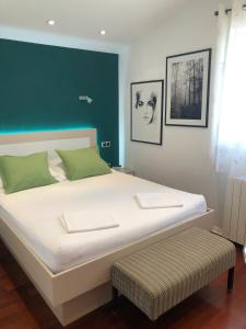 a bedroom with a large white bed with a green wall at Apartmani ROBERTA in Bol