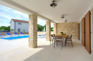 a patio with a table and chairs and a pool at Villa Zala in Rasopasno