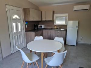 een keuken met een witte tafel en stoelen en een witte koelkast bij Siófok Sophia Apartman in Siófok