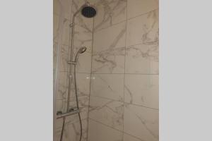 uma casa de banho com chuveiro e azulejos de mármore em T2 calme et design quartier Chartrons à Bordeaux em Bordéus