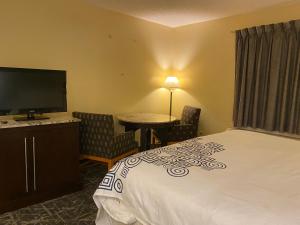 a hotel room with a bed and a desk and a television at Knights Inn & Suites Dublin in Dublin