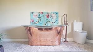 a bathroom with a copper tub and a toilet at R & R BERGERAC in Bergerac