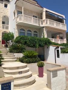 a white house with stairs in front of it at Apartmani ROBERTA in Bol