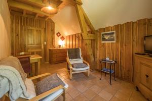 a living room with a couch and a chair and a television at chambre d'hôte Chez Tourache in Saint-Jacques-en-Valgodemard