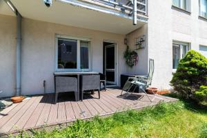 un patio con una mesa y una silla en una terraza en Victus Apartamenty, Apartament Sopot, en Sopot