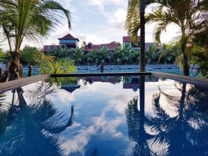 伊頓島的住宿－Eden Island by Olala Homes，棕榈树游泳池和背景建筑