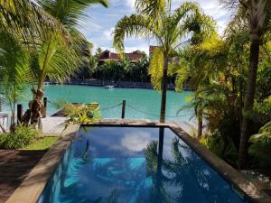een zwembad tegenover een resort met palmbomen bij Eden Island by Olala Homes in Eden Island