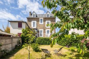 ein großes Haus mit zwei Stühlen im Hof in der Unterkunft La Villa Souhaitier in Saint-Malo