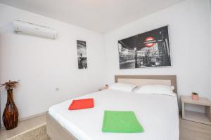 Un dormitorio con una cama blanca con una toalla verde. en Unirii Suites, en Bucarest