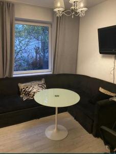 a living room with a black couch and a table at Secret Garden by Arder in Gdynia