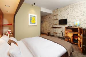 a bedroom with a white bed and a tv at 25hours Hotel Hamburg HafenCity in Hamburg
