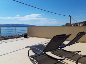 two chairs on a balcony with a view of the water at H&T in Senj