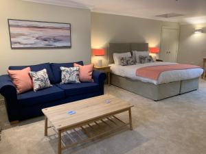 uma sala de estar com uma cama e um sofá azul em Caley em Hunstanton