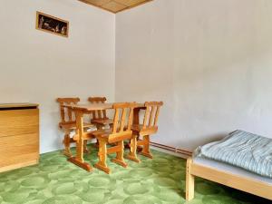 Zimmer mit einem Tisch, Stühlen und einem Bett in der Unterkunft Apartmán Bušín in Busin