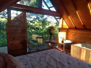 a room with a large window in a cabin at Cabaña Arrayanes in Rionegro