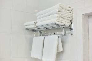 a pile of towels on a towel rack in a bathroom at Family Hotel Happy INN in Zatoka +79 photos