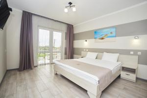 a bedroom with a bed and a large window at Family Hotel Happy INN in Zatoka