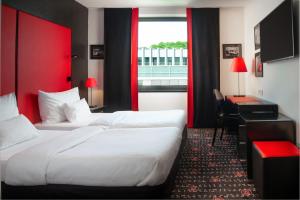 a hotel room with two beds and a large window at OREA Hotel Angelo Praha in Prague