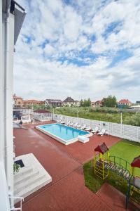 a swimming pool on a patio with chairs around it at Family Hotel Happy INN in Zatoka