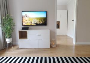 a living room with a tv on a white cabinet at Bulwar Gdynia in Gdynia