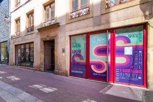 une façade de magasin avec des fenêtres colorées sur une rue de la ville dans l'établissement Flow Hostel - un cocon au cœur de Metz, à Metz